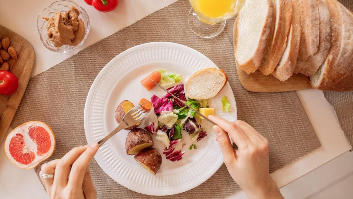Top view of a nutritious breakfast setup with salad, bread, and fresh juice, perfect for a healthy start.